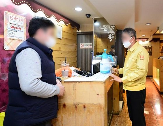 지난해 3월 코로나19 방역 강화를 위해 서울의 한 구청 직원이 구내 다중이용시설을 점검하고 있다. 중앙포토
