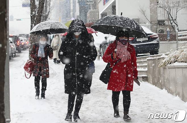 폭설이 내리고 있는 12일 오후 서울 서초구 교대역 인근에서 우산을 쓴 시민들이 발걸음을 재촉하고 있다. 2021.1.12/뉴스1 © News1 임세영 기자