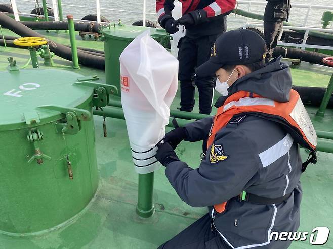 해경 대원이 해양 오염 예방을 위해 급유선 에어벤트를 막고 있다.(인천해양경찰서제공) /© 뉴스1