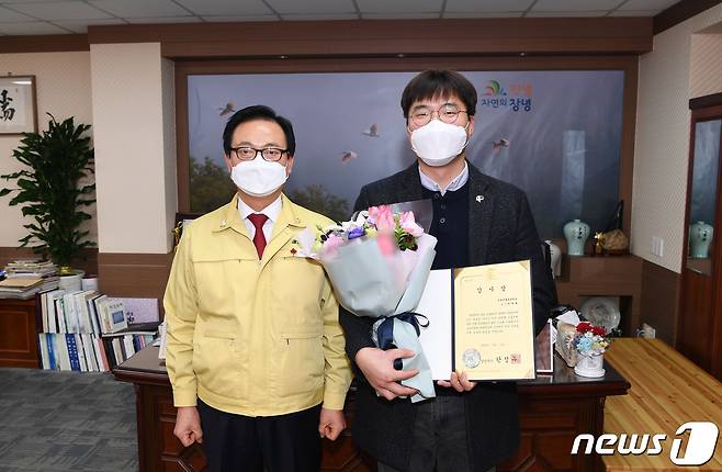 행방이 묘연했던 따오기를 발견해 신고한 박대현씨(오른쪽)가 한정우 창녕군수(왼쪽)로부터 감사장을 받고 기념촬영을 하고 있다. © 뉴스1