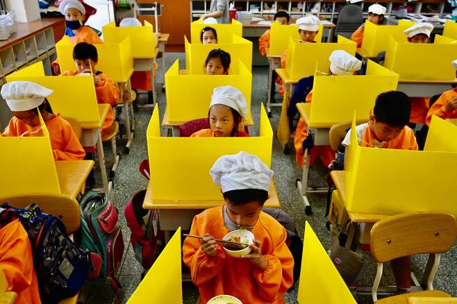 지난해 4월 대만 타이베이에 있는 한 초등학교에서 학생들이 플라스틱 가림막을 설치한 채 점심식사를 하고 있다. 이 사진은 AFP통신이 지난해 12월 말 '올해의 사진'으로 선정해 배포했다. /AFP 연합뉴스