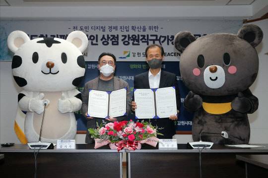 13일 강원도청 본관에서 김기록(왼쪽) 코리아센터 대표와 최문수 강원도 도지사가 '강원도형 간편 온라인 상점 보급사업'을 위한 협약서를 체결한 뒤 기념촬영을 하고 있다. <코리아센터 제공>