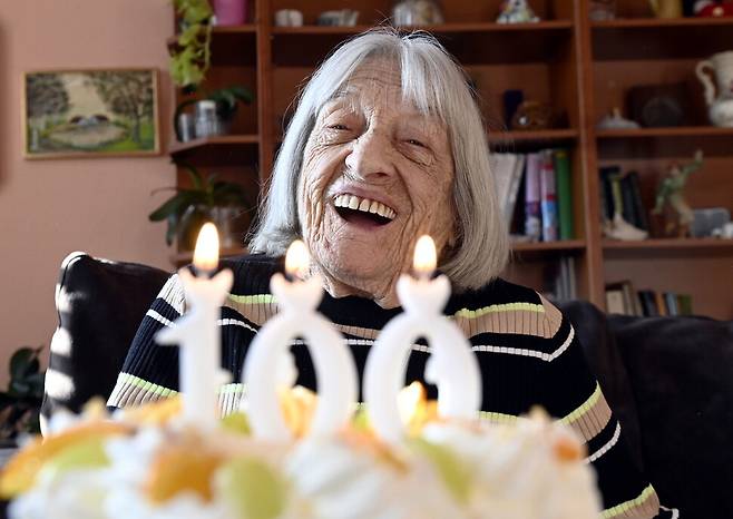 올림픽 챔피언 아그네스 켈레티가 1월7일(현지시각) 헝가리 부다페스트 자택에서 생일 케이크를 받은 뒤 웃고 있다. 홀로코스트 생존자 켈레티는 9일 100살이 됐다. 부다페스트/EPA 연합뉴스