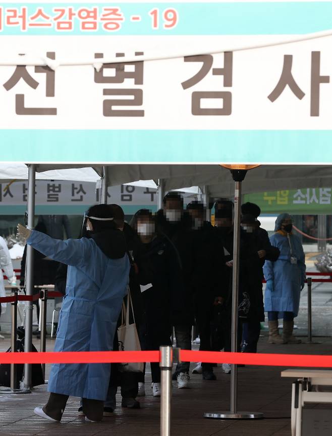 13일 오전 서울시청 앞 임시선별진료소에서 코로나19 진단 검사를 받기 위해 시민들이 줄을 서 있다. 연합뉴스
