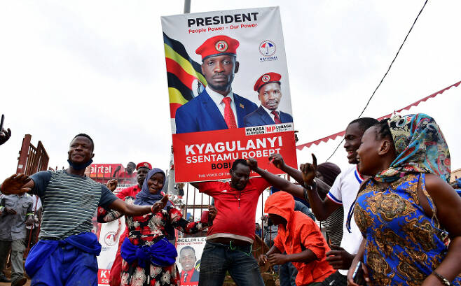 35년간 집권한 요웨리 무세베니 우간다 대통령에 맞서 야당 대통령 후보로 출마한 래퍼 출신 정치인 보비 와인(본명 로버트 캬굴라니 센타무)의 지지자들이 12일(현지시간) 우간다 캄팔라 거리에서 춤추며 선거 유세를 하고 있다. 캄팔라 | 로이터연합뉴스