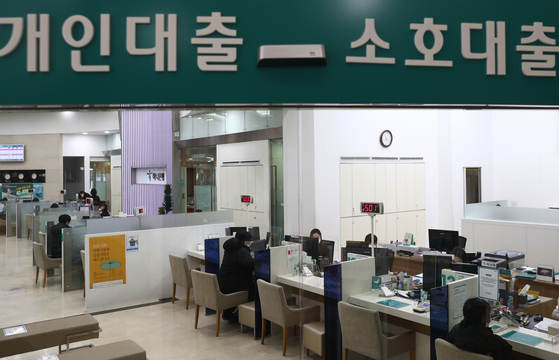 Customers speak with bank employees about loan programs at a bank in central Seoul. [YONHAP]