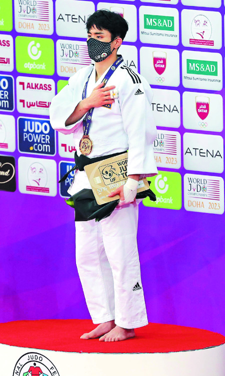 김원진이 12일 카타르 도하 루사일 스포츠 아레나에서 열린 2021 도하 마스터스 대회 첫날 남자 60㎏급 메달 세리머니에서 금메달을 목에 건 채 게양되는 태극기를 바라보고 있다. AFP연합뉴스