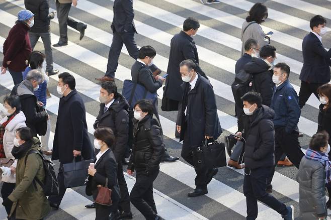 일본이 코로나19 확산으로 비상인 가운데 13일 도쿄에서 마스크를 쓴 시민들이 횡단보도를 건너고 있다. 일본은 이날 코로나19 누적 확진자가 30만 명을 넘어선 것으로 추산된다고 공영방송 NHK 등 현지 언론이 보도했다. AP연합뉴스