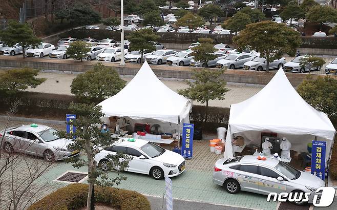 11일 오후 부산 연제구 부산아시아드주경기장 주차장에서 택시 기사들이 드라이브 스루로 신종 코로나바이러스 감염증(코로나19)검사를 받고 있다. 부산시는 오는 15일까지 지역 내 무증상 감염자 조기 발견을 위해 택시 운수종사자를 대상으로 '찾아가는 이동 선별검사소'를 운영한다. 2021.1.11/뉴스1 © News1 여주연 기자