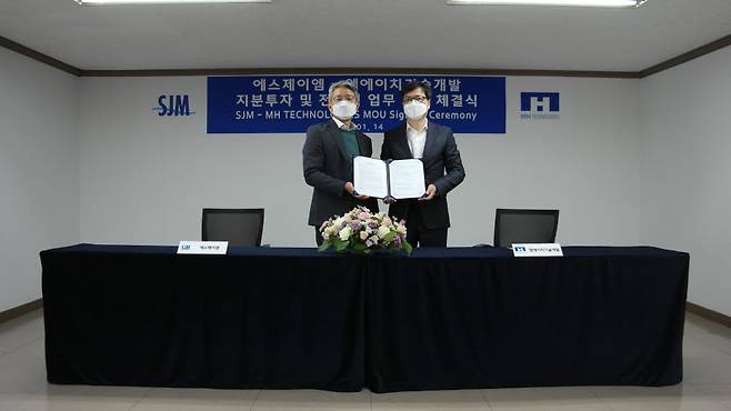김휘중 SJM 부회장, 유진호 MH기술개발 대표가 14일 SJM 본사에서 지분투자 및 전기차 핵심 냉각 부품 관련 사업 연계·협력을 위한 업무협약(MOU)을 체결했다.