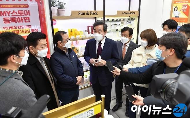 이낙연 더불어민주당 대표(가운데)가 14일 코로나 이익공유제 실현 현장 방문의 일환으로 서울 영등포 지하상가 내 네이처컬렉션을 찾아 정기화 가맹점주(이 대표 왼쪽)의 얘기를 듣고 있다.