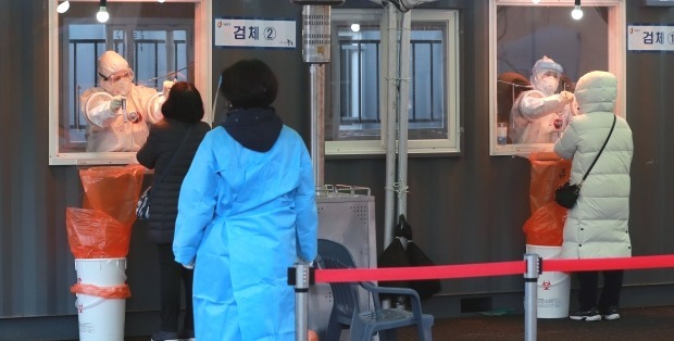 서울역 광장에 마련된 신종 코로나바이러스 감염증(코로나19) 임시선별진료소에서 의료진이 피검사자의 검체를 채취하고 있다. /뉴스1