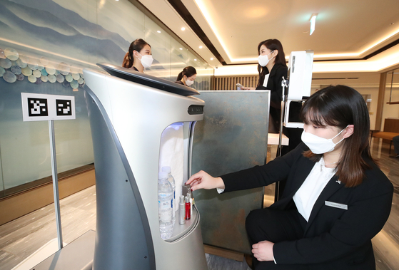 An employee at the five-star Daegu Marriott Hotel, which officially opened on Jan. 9, places water and shower products on a robot. According to KT, the newly opened hotel uses robots and runs on its artificial intelligence system. [KT]