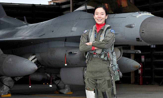 여군 최초로 전술무기교관 자격을 획득한 공군 39정찰비행단 159전투정찰비행대대 소속 김선옥 소령이 F-16 전투기 앞에서 포즈를 취하고 있다. 공군 제공