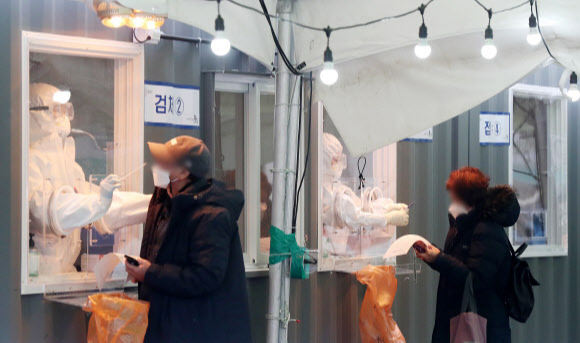 지난 11일 오전 서울 중구 서울역광장에 마련된 임시선별검사소를 찾은 시민들이 신종 코로나바이러스 감염증(코로나19) 진단검사를 받고 있다. 뉴스1