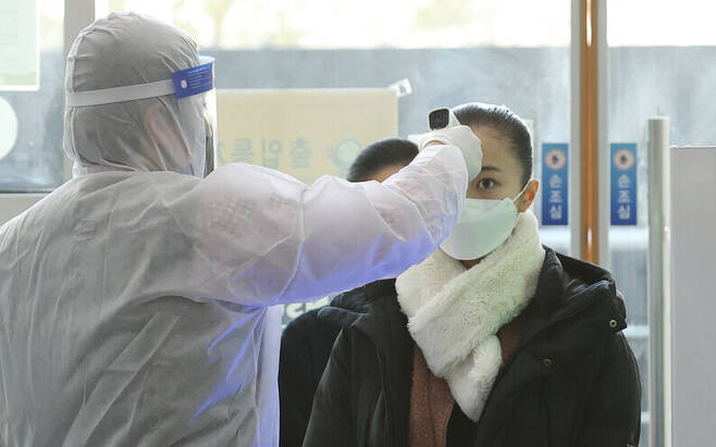 Students looking to major in modern dance at Hansung University get their temperature checked before taking a practical exam on Jan. 14. (Yonhap News)