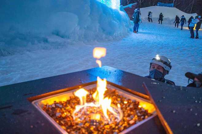 A worker lights a gas warmer at Ice Castles in North Woodstock, New Hampshire, on Thursday. (AFP-Yonhap)