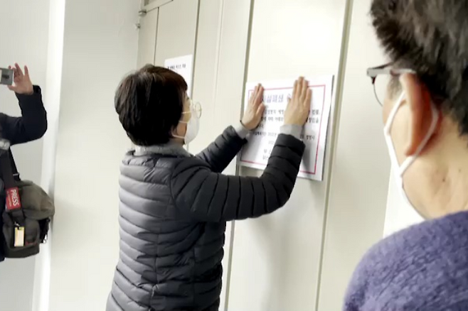 지난 11일 오전 부산 서구청 관계자가 서부장로교회에 시설폐쇄 안내문을 부착하고 있다. 부산 서구청 제공