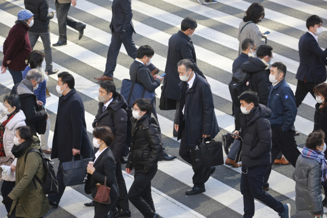 일본이 신종 코로나바이러스 감염증(코로나19) 확산으로 비상인 가운데 13일 도쿄에서 마스크를 쓴 시민들이 횡단보도를 건너고 있다./연합뉴스