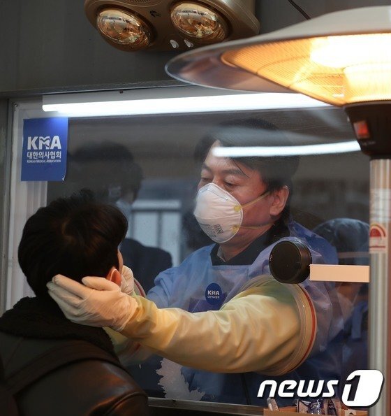 안철수 국민의당 대표가 15일 서울 중구 서울광장에 마련된 임시 선별검사소에서 의료자원봉사에 나서 검체를 채취하고 있다. 뉴스1