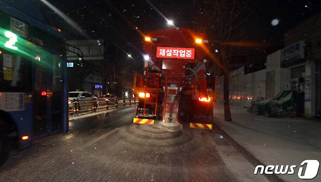 전국 곳곳에 대설 특보가 발효중인 17일 저녁 눈이 내린 서울 동작구 장승배기역 인근 상도로에서 제설 차량이 도로에 염화칼슘을 뿌리며 이동하고 있다. (동작구청 제공) 2021.1.17/뉴스1