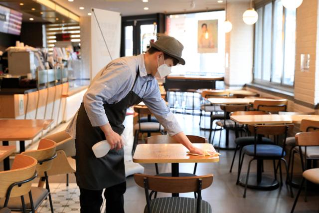 17일 서울 마포구의 한 카페에서 직원이 테이블을 닦으며 손님을 맞을 준비를 하고 있다. 뉴시스