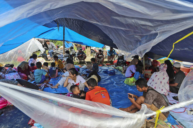 17일(현지시간) 인도네시아 술라웨시섬 마무주에서 집을 잃은 이재민들이 천막 대피소에 모여있다. /AP연합뉴스