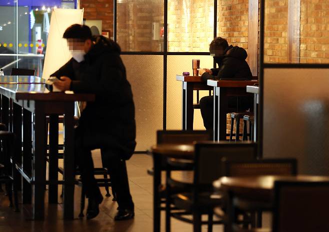 카페에서 오후 9시까지 매장에서 취식이 허용된 첫날인18일 서울 중구의 한 카페에 시민들이 앉아있다.(사진=연합뉴스)