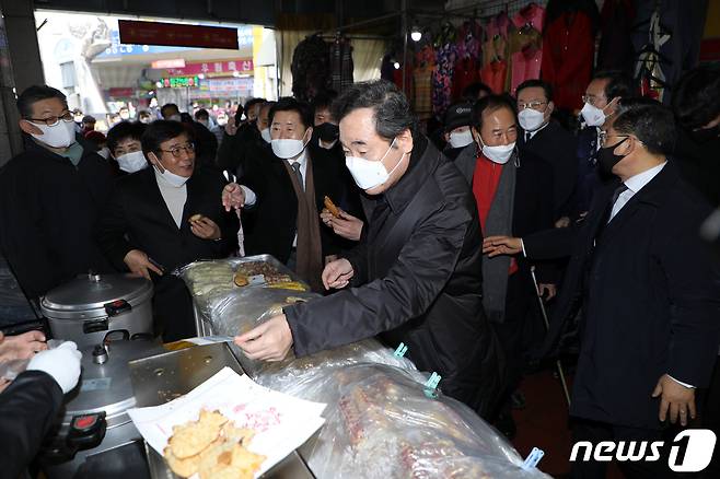 광주를 찾은 이낙연 더불어민주당 대표가 18일 오후 광주 서구 양동시장에서 온누리 상품권으로 붕어빵을 사고 있다.2021.1.18/뉴스1 © News1 허단비 기자