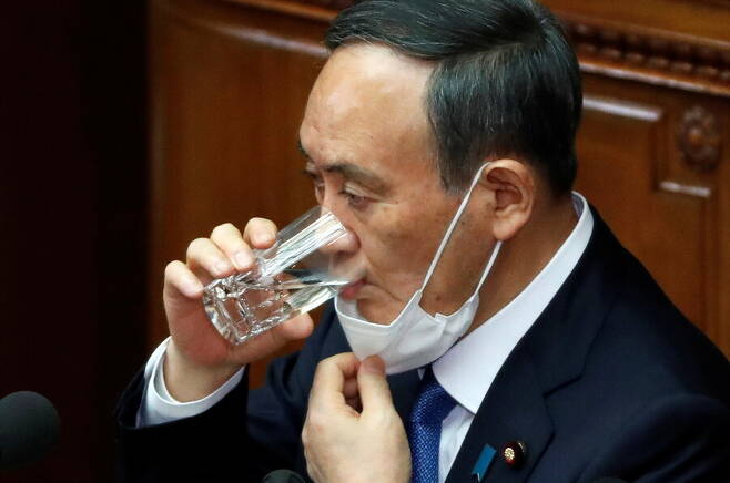 스가 요시히데 일본 총리가 18일 정기국회 개원을 계기로 시정연설을 하는 도중 물을 마시고 있다. 도쿄/로이터 연합뉴스