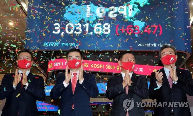 Officials at Korea Exchange celebrate during a ceremony to mark the benchmark Korea Composite Stock Price Index`s (KOSPI) breakthrough of the 3,000-point mark for the first time in its history on Jan. 7, 2021, when the index soared 63.47 points, or 2.14 percent, to close at 3,031.68 points.