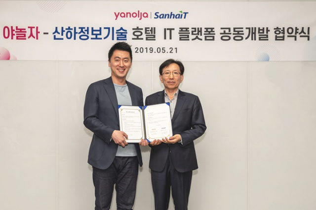 김종윤(왼쪽) 야놀자 온라인부문 대표와 손학기 산하정보기술 대표가 지난 2019년 5월 호텔 IT 플랫폼 공동개발을 위한 협약을 맺고 협약서를 들어보이고 있다. / 사진제공=야놀자