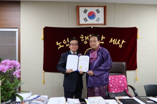 김호일 대한노인회장에게 홍보대사 위촉장을 받는 김수형 감독.(왼쪽)