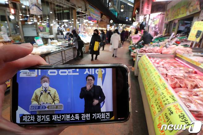 경기도가 신종 코로나바이러스 감염증(코로나19)으로 인한 경제 위기 극복을 위해 2차 재난기본소득을 지급한다고 밝힌 20일 오전 경기도 수원시 못골시장을 찾은 시민들이 물건을 구매하고 있다. 이재명 지사는 이날 기자회견을 통해 전 도민에게 지역화폐로 1인당 10만원을 지급한다고 발표했으며 코로나19 방역상황 등을 고려해 지급 시기 등에 대해서는 결정을 미뤘다. 2021.1.20 /뉴스1 © News1 조태형 기자