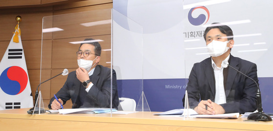 Kim Seong-wook, director general of the international finance bureau at the Ministry of Economy and Finance, left, speaks during a briefing held Tuesday on measures to maintain foreign currency liquidity at Government Complex Sejong. [YONHAP]