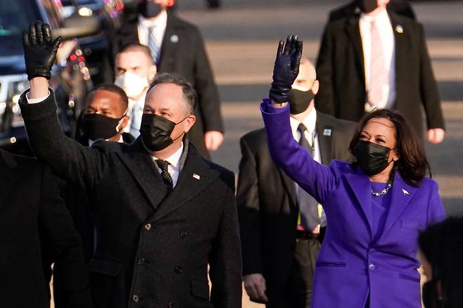 카멀라 해리스 미국 부통령이 20일(현지 시각) 남편 더글러스 엠호프와 함께 백악관으로 향하면서 손을 흔들고 있다. /로이터 연합뉴스