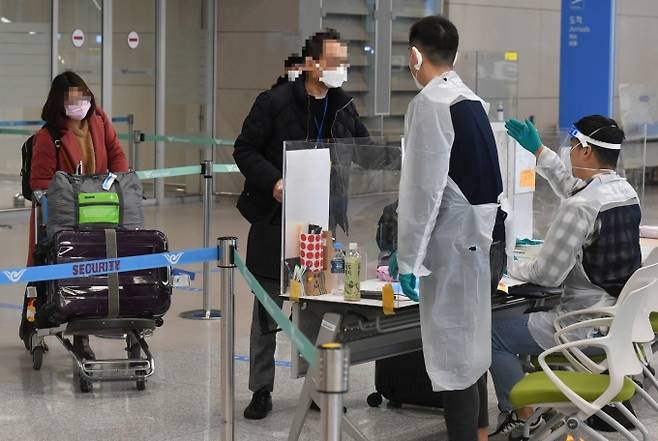 인천국제공항 제2여객터미널에서 방역 관계자들이 해외 입국자들에게 동선을 안내하고 있다. 사진은 기사 본문과 관련이 없음. 2021.01.08. 박태현 기자