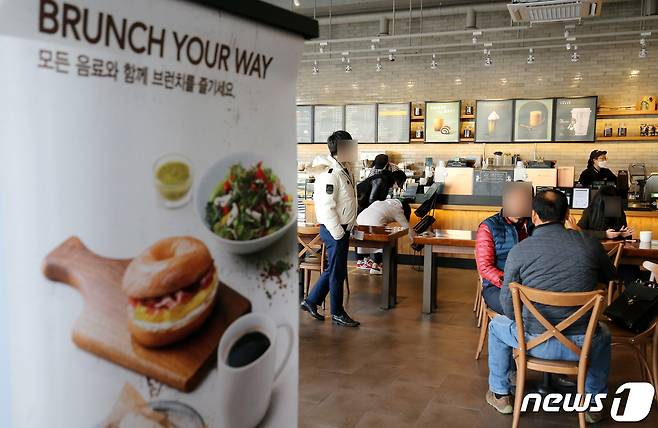 포장·배달만 가능했던 카페에서 매장 내 취식이 가능해진 18일 대전시내 카페를 찾은 시민들이 테이블에 앉아 커피를 마시고 있다. 2021.1.18/뉴스1 © News1 김기태 기자