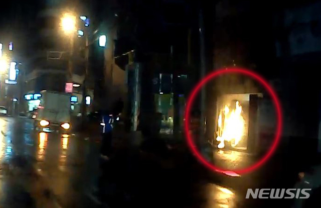 [부산=뉴시스] 21일 밤 부산 사하구의 한 건물 입구에서 발생한 화재. (사진=부산경찰청 제공)