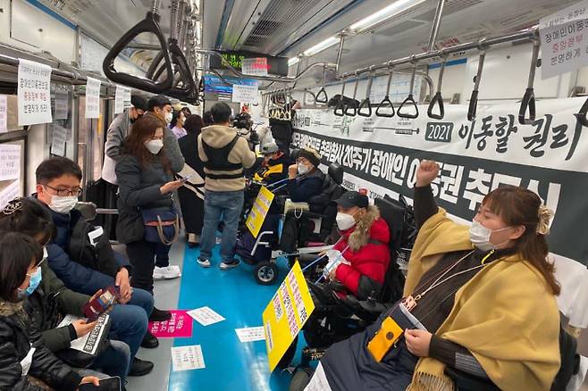 전국장애인차별철폐연대(전장연)가 지하철 4호선 오이도역에서 당고개행 방면 열차를 타고 서울역으로 향하며 '이동할 권리'를 주장하고 있다. 전장연 제공