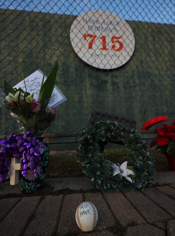 ATLANTA, GEORGIA - JANUARY 22: Fans pay tribute after the death of MLB Hall of Famer Hank Aaron at the marker where Aaron broke the record and hit his 715th homer at the former site of Atlanta?Fulton County Stadium on January 22, 2021 in Atlanta, Georgia. Kevin C. Cox/Getty Images/AFP
