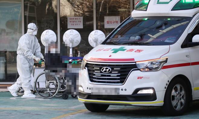 지난해 12월 31일 오전 서울 구로구의 한 요양병원에서 관계자가 환자를 구급차로 옮기고 있다./연합뉴스