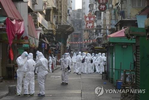 23일 전격 봉쇄된 홍콩 도심의 건물들 앞의 방역 요원들 [AP=연합뉴스]