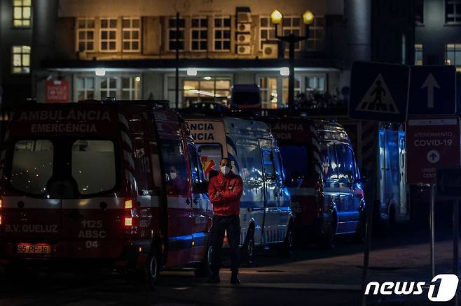 지난 22일 포르투갈 리스본의 한 병원 앞에 세워진 구급차 옆에서 소방요원이 대기 중이다. © AFP=뉴스1