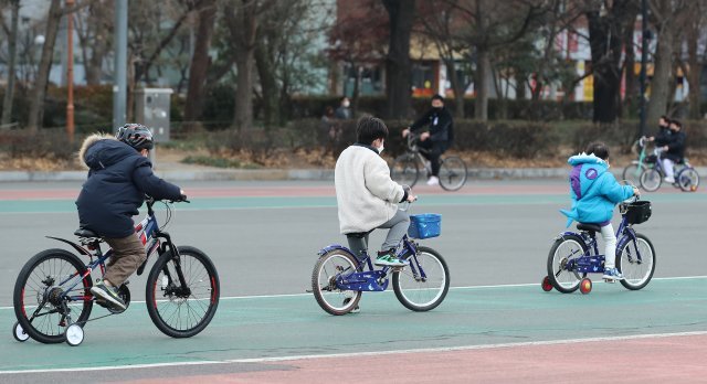 24일 대구 지역 낮 기온이 10도를 웃도는 포근한 날씨 속에 달서구 두류공원 인라인스케이트장을 찾은 시민들이 마스크를 쓴 채 자전거를 타고 있다. 뉴스1