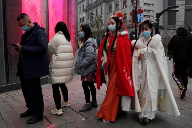 전통의상을 입은 중국 우한 시민들이 거리를 걷고 있다.  /사진=AP