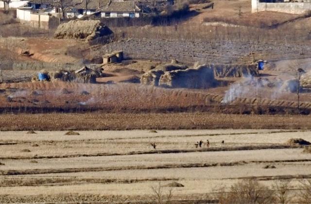 개풍군 마을에서 주민들이 짚을 태우며 논갈이를 준비하고 있다.