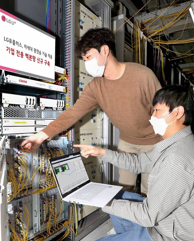 LG유플러스 직원들이 신규 구축한 기업 전용 백본망의 광전송장비를 점검하고 있는 모습./사진=LGU+