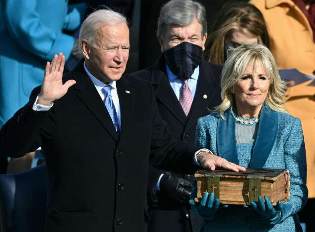조 바이든이 질 바이든(오른쪽) 미국 영부인 옆에서 제46대 미국 대통령 취임식에서 선서를 하고 있다./연합뉴스=AFP
