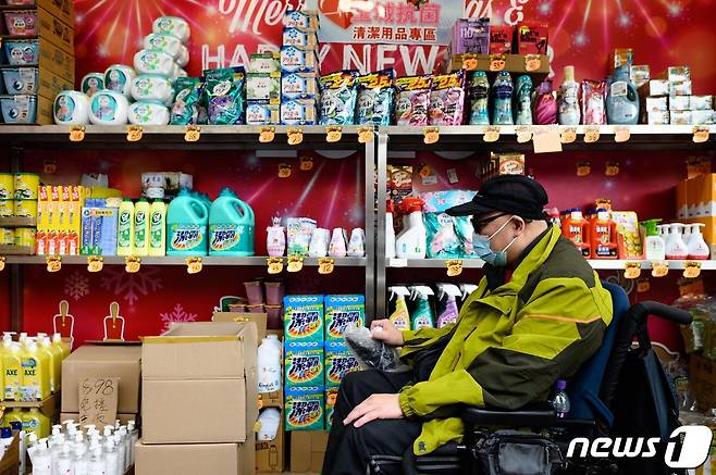 지난해 2월13일 홍콩의 한 슈퍼마켓에서 휠체어를 탄 남성이 생필품 옆을 지나가고 있다. © AFP=뉴스1